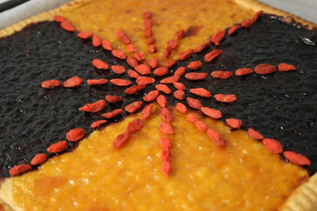 crostata con marmellata di albicocca e mirtilli, decori di goji